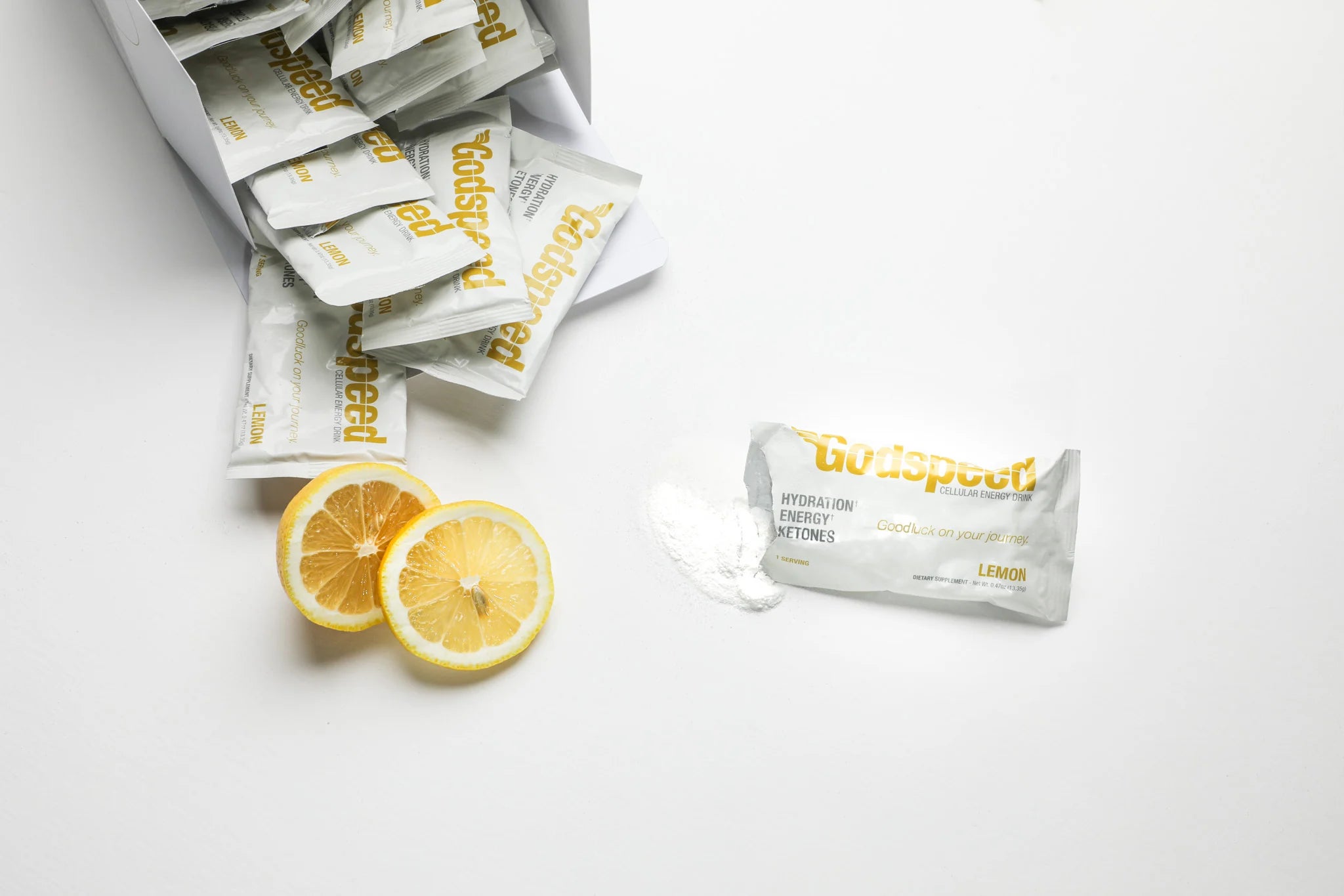 Godspeed box spilling lemon stick packs beside sliced lemons